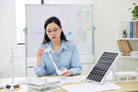 研究太阳能风力发电的青年女性图片