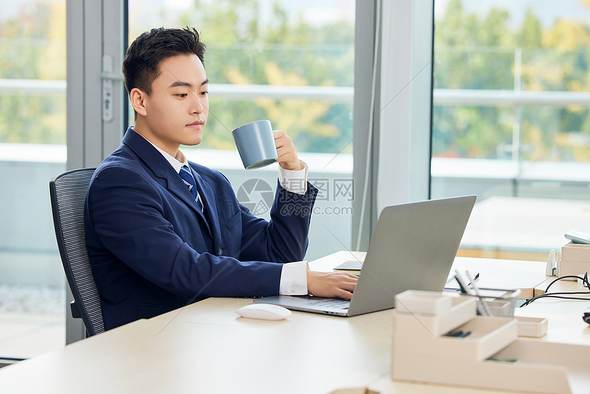 手拿水杯的职场男性图片