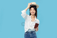 戴草帽的青年女子手拿护照和机票图片