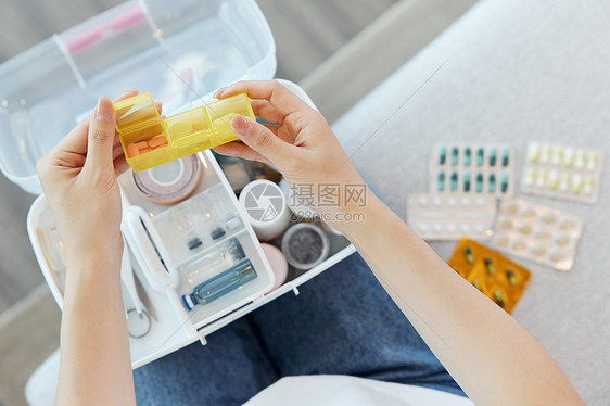 居家女性从家用医疗箱拿出药品图片