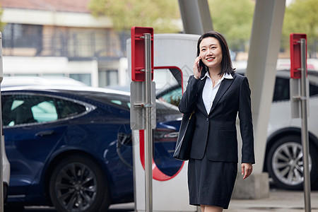 寻找新能源汽车充电桩的商务女性图片