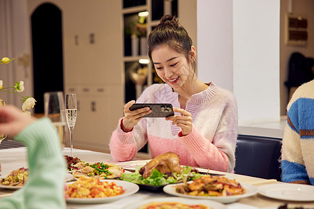 美女用手机给食物拍照图片