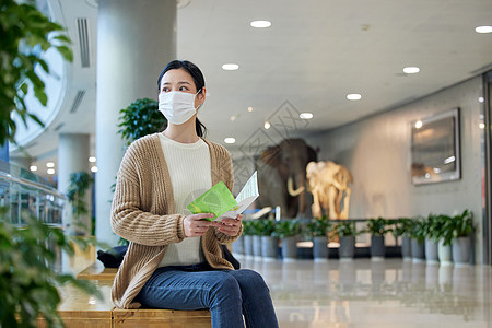 戴口罩的女性手拿导览手册高清图片