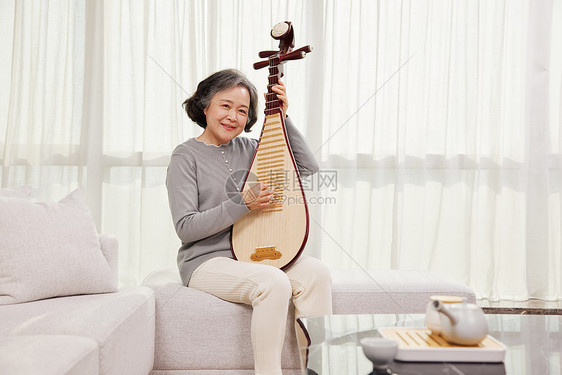 老奶奶在家弹奏乐器琵琶图片