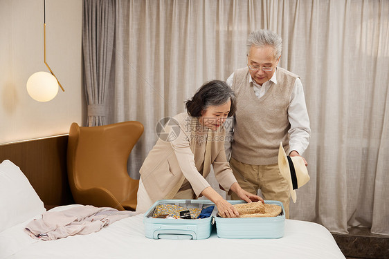 旅行的老年夫妻使用行李箱整理图片
