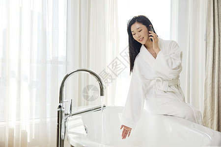 年轻浴袍美女浴室打电话图片