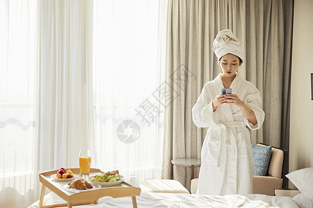 数字健康年轻美女酒店下午茶休息玩手机背景
