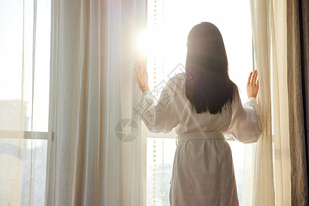 休闲酒店美女酒店早晨起床拉开窗帘背影背景
