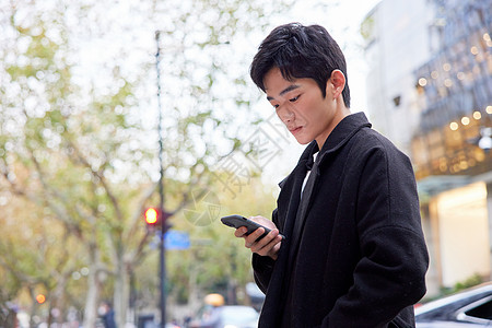 年轻男性街头使用手机高清图片