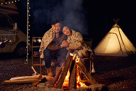 房车野营年轻夫妻户外露营烤火取暖背景