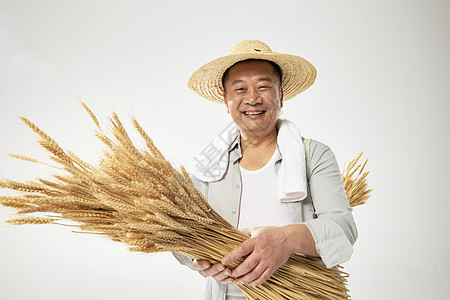 抱稻草农民伯伯抱着小麦的农民伯伯笑容背景