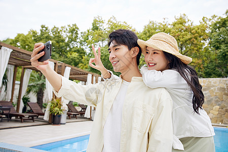 夫妻度假酒店放松的年轻情侣手机拍照背景