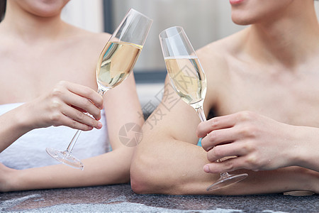 泡温泉的情侣喝香槟特写图片