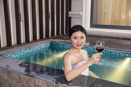 青年女性泡温泉喝红酒图片