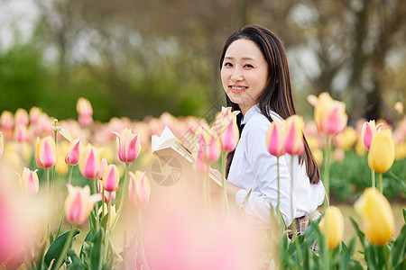 唯美郁金香花海坐在郁金香花海里看书的制服少女背景