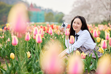 春季踏青手拿照相机的制服少女背景图片