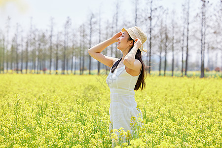 油菜花田的女孩少女站在油菜花田享受阳光背景