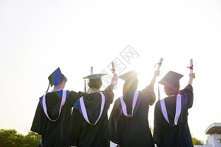 我们毕业啦大学生手举着毕业证背影背景