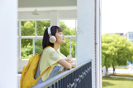 听音乐的女青年校园里听音乐的女大学生形象背景