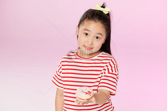 小女孩拿着甜甜圈图片