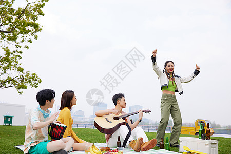 夏日美女草地上青年人野餐弹琴跳舞背景