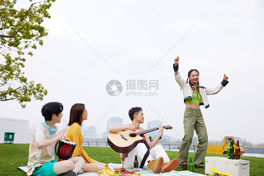 草地上青年人野餐弹琴跳舞图片