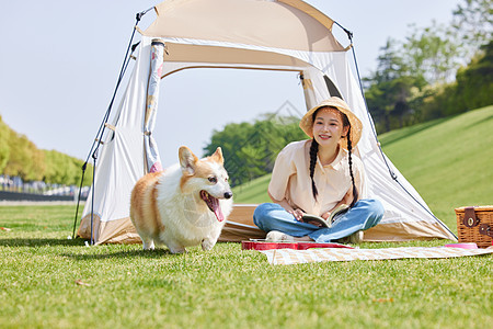 青年女性与宠物狗公园野餐露营图片
