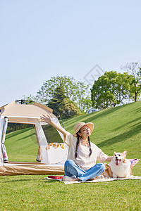 狗训练露营晒太阳的青年女性和宠物狗背景