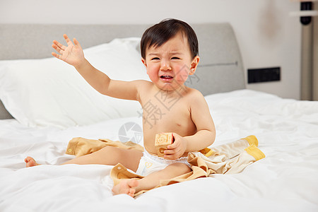 坐在床上哭闹的婴儿宝宝图片
