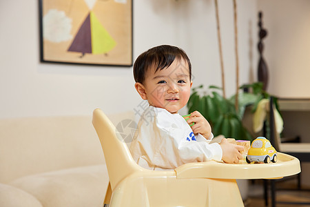 笑脸开心坐在宝宝椅上开心笑的婴幼儿背景