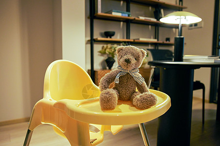 可爱黄色玩具熊室内宝宝椅上的玩具熊背景
