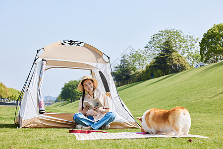 年轻女性带狗公园露营搭帐篷图片