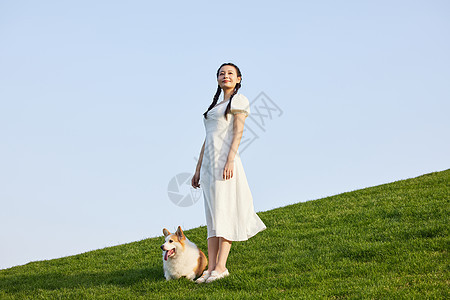 青年女性户外遛狗形象图片