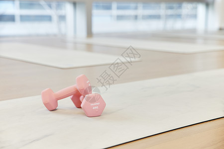 瑜伽垫上的粉色哑铃图片