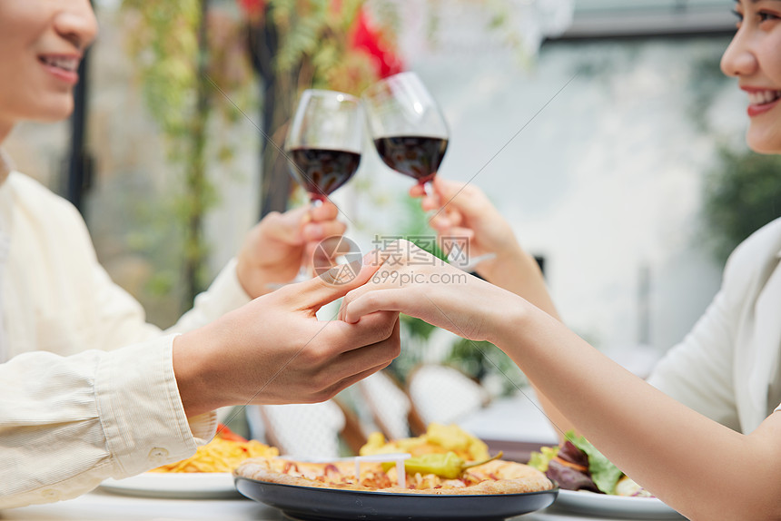 甜蜜情侣喝红酒碰杯特写图片