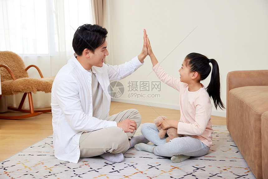 父亲与女儿在客厅玩耍击掌图片