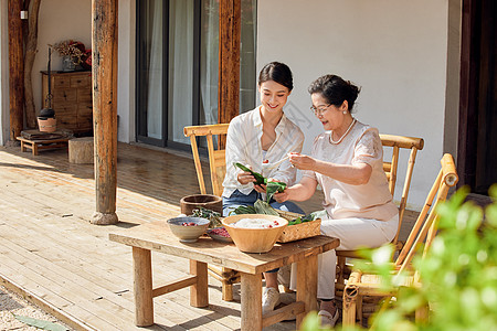 端午节母女二人在院子里包粽子背景