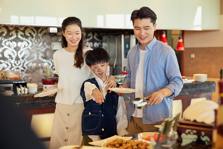 自助餐厅里一家三口挑选美食图片