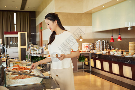 女性在自助餐厅挑选美食图片