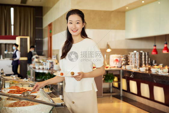 女性在自助餐厅取餐图片