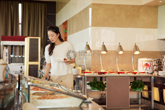 女性在自助餐厅取餐图片