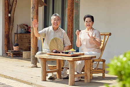 养老度假老年夫妻院子里喝茶打招呼背景