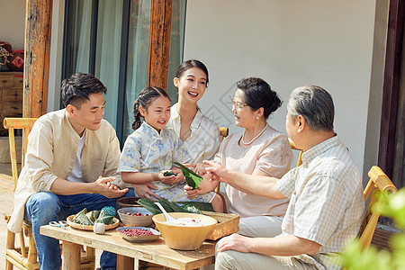 端午节在院子里包粽子的一家人高清图片