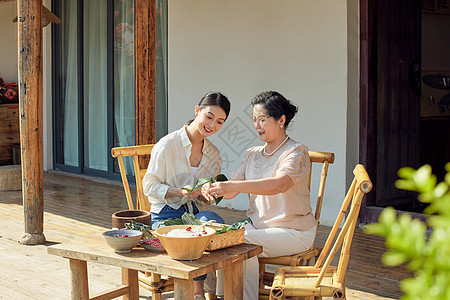 婆媳二人在院子里包粽子高清图片