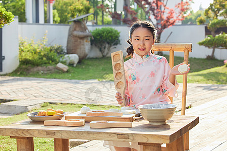 院子里穿着汉服的小女孩制作月饼图片