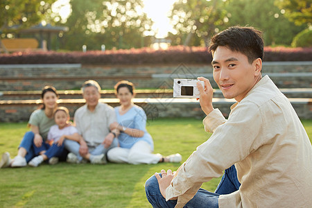 室外给家人拍照的男性图片