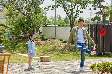 亲子教育父亲和女儿在院子里踢毽子背景