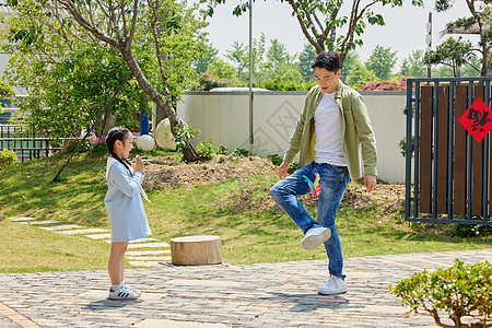 父亲和女儿在院子里踢毽子图片