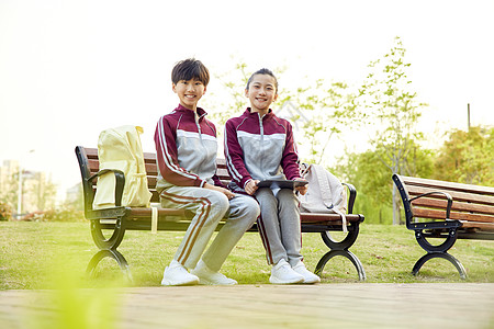 放学坐在长椅上的小学生高清图片