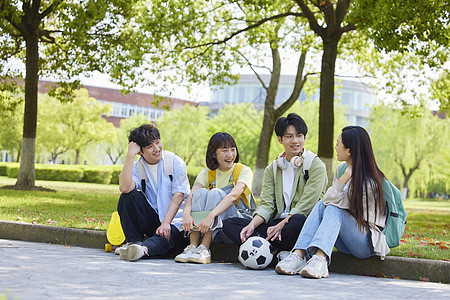 大学生们坐在校园草地边图片